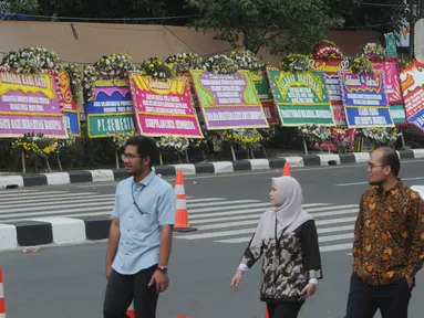 Pejalan kaki melintasi karangan bunga ucapan selamat yang berjejer di sekitar Gedung Merah Putih KPK, Jakarta, Jumat (20/12/2019). Papan karangan bunga tersebut berisi ucapan selamat terhadap dilantiknya pimpinan KPK periode 2019-2023. (merdeka.com/Imam Buhori)