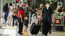 Calon penumpang membawa anaknya berjalan di Stasiun Senen, Jakarta, Sabtu (23/10/2021). PT Kereta Api Indonesia (Persero) kembali memperbolehkan anak-anak usia di bawah 12 tahun naik KA Jarak jauh mulai 22 Oktober 2021. (Liputan6.com/Faizal Fanani)