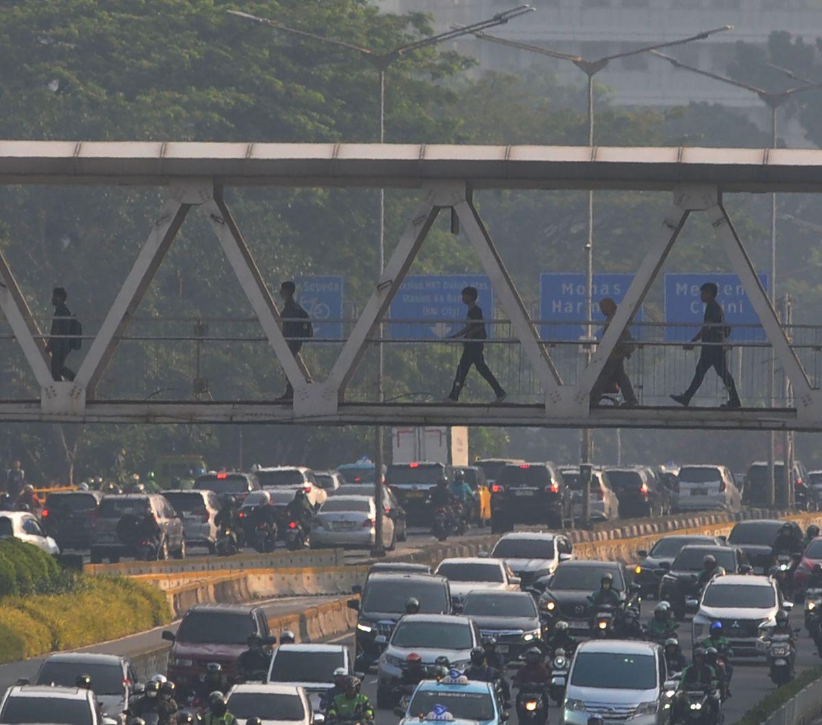 Sejumlah pekerja berjalan melewati Jembatan Penyeberangan Orang (JPO)&nbsp;di kawasan Jalan Sudirman, Jakarta, Selasa (27/8/2024). Badai pemutusan hubungan kerja (PHK) menghantam Indonesia. Berdasarkan data Kementerian Tenaga Kerja (Kemnaker),&nbsp;terdap