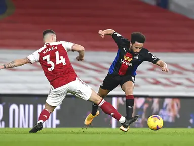 Pemain Crystal Palace Andros Townsend (kanan) menggiring bola melewati pemain Arsenal Granit Xhaka pada pertandingan Liga Inggris di Emirates Stadium, London, Inggris, Kamis (14/1/2021). Pertandingan berakhir imbang 0-0. (Neil Hall/Pool via AP)