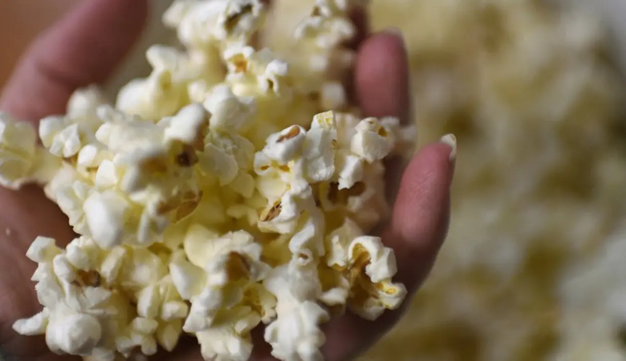 Kandungan karbohidrat dan tryptophan (asam amino) di dalam popcorn dapat menghasilkan hormon serotonin sehingga dapat membuat tubuh menjadi lebih rileks dan lebih mudah untuk tidur. (AFP PHOTO / LOIC VENANCE)