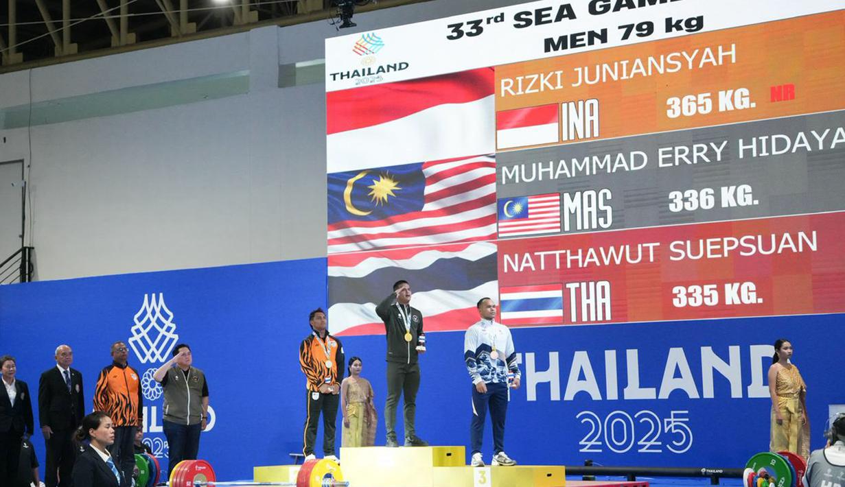 Lalu di total angkatan, Rizki Juniansyah membukukan 365kg yang juga berstatus rekor dunia. Dia unggul sangat jauh dari peraih medali perak asal Malaysia, Muhammad Erry Hidayat yang membukukan 336kg. (Dok Kemenpora RI)