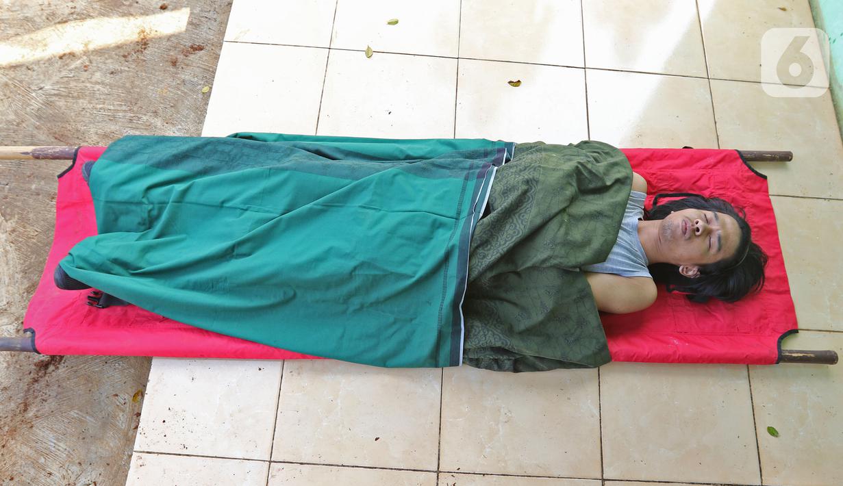 Pelanggar PSBB mempraktikkan prosesi pemakaman saat terjaring razia di kawasan Stadion Pakansari, Kabupaten Bogor, Minggu (6/9/2020). Pemkab Bogor menerapkan sanksi denda serta sosial untuk memberi efek jera bagi warga yang tidak menggunakan masker di tempat umum. (Liputan6.com/Herman Zakharia)