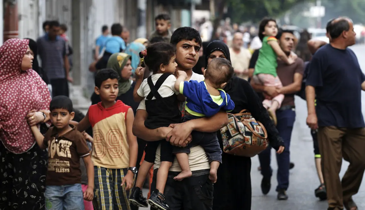 Puluhan keluarga beserta anak-anak harus keluar dari Shujayeh, (20/7/2014), menyusul meningkatnya serangan militer Israel ke Gaza, Palestina. (REUTERS/Finbarr O'Reilly)