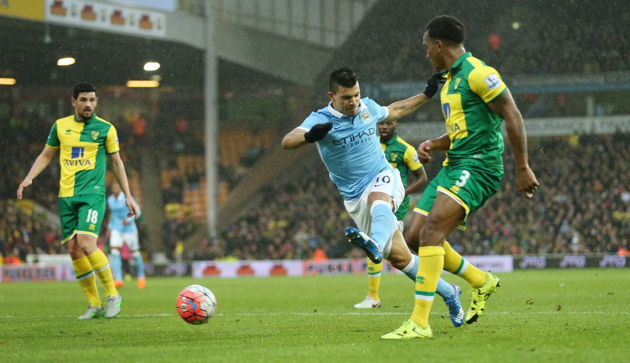  Pemain Manchester City,  Sergio Aguero melakukan tembakan yang berbuah gol saat dihadang para pemain Norwich City pada laga Babak ketiga Piala FA di Stadion Carrow Road, Norwich, Sabtu (9/1/2016)  (Reuters/Alex Morton)