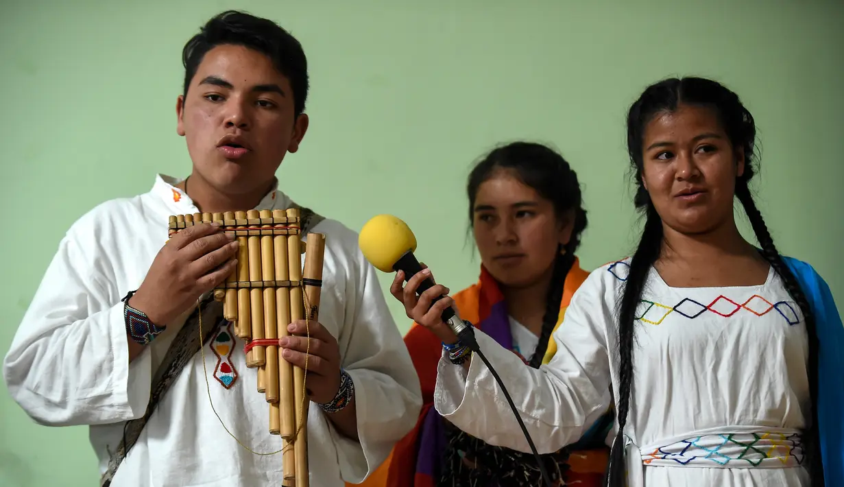 Penduduk asli Kolombia bermain musik adat mereka saat mengikuti perayaan Hari Internasional Penduduk Asli / Masyarakat Adat di Bogota (9/8). (AFP Photo/Raul Arboleda)