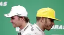 Ekspresi dua pebalap Mercedes GP, Nico Rosberg (kiri) dan Lewis Hamilton, di podium juara F1 GP Brasil di Sirkuit Interlagos, Sao Paulo, Brasil, Senin (16/11/2015) dini hari WIB. (EPA/Fernando Bizerra Jr)