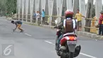 Seorang bocah mengambil uang yang dilempar pengguna jalan di Jembatan Cikalong, Jawa Barat, Sabtu (2/7). Memasuki mudik Lebaran, jumlah pencari uang sedekah di kawasan itu meningkat dibanding hari biasa (Liputan6.com/Gempur M Surya)