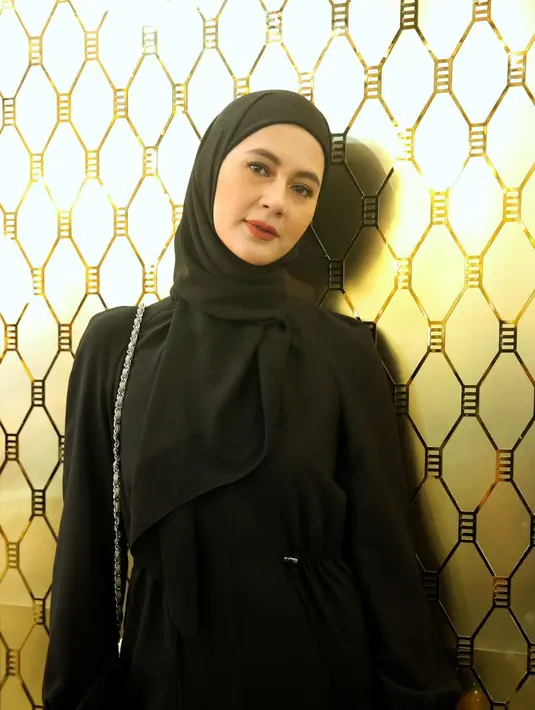Paula Verhoeven tampil dengan gaun hitam lengan panjang dan hijab yang serasi. Ditambah riasan natural dengan lipstik merah maroon. / Foto: Adrian - Fimela.com.