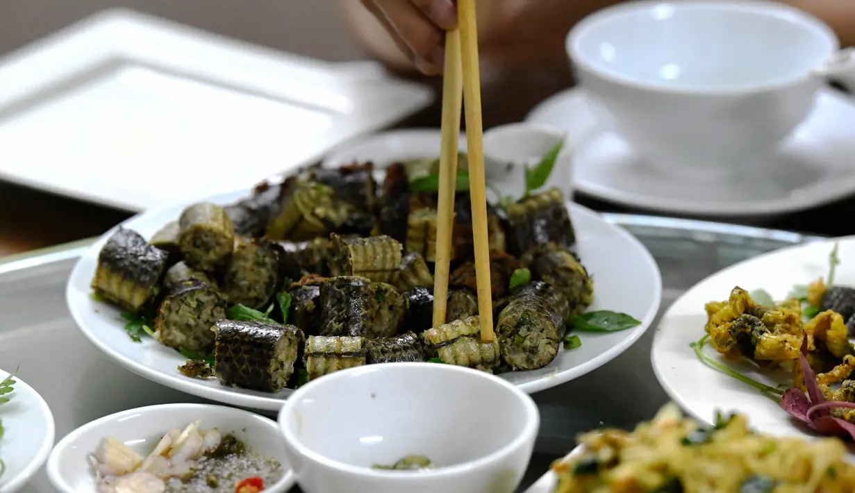 Foto pada 24 Agustus 2018 memperlihatkan pelanggan menyantap olahan daging ular di sebuah restoran khusus provinsi Yen Bai, Vietnam. Daging ular menempati peringkat pertama sebagai hidangan ekstrem yang digemari banyak orang Vietnam. (AFP/Nhac NGUYEN)