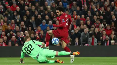 Striker Liverpool, Mohamed Salah berusaha melewati kiper Red Star Belgrade Milan Borjan selama pertandingan grup C Liga Champions di stadion Anfield, Inggris (24/10). Salah mencetak dua gol dan mengantar Liverpool menang 4-0. (AP Photo/Jon Super)