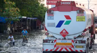 Banjir rob atau air laut pasang menggenangi ruas jalur pantura Semarang-Demak, Jawa Tengah, Minggu (12 /06/2016). Meski banjir yang cukup tinggi hanya kendaraan besar truk atau bus yang bisa melintas. (Gholib)