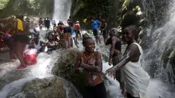 Sejumlah  peziarah mandi di bawah air terjun di Saut d' Eau, Haiti, (16/7). Ini merupakan ritual tahunan untuk menyembuhkan penyakit dan mensucikan diri. (REUTERS/Andres Martinez Casares)