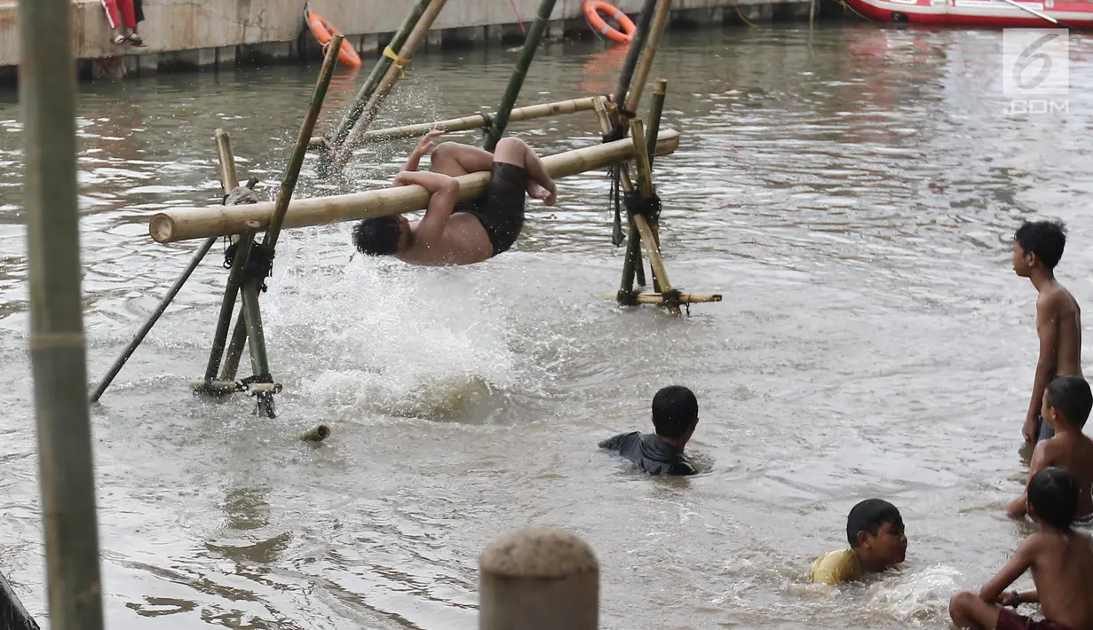 Seorang peserta berhasil menjatuhkan lawannya ke air saat mengikuti lomba gebuk bantal dalam Festival Kalimalang di Cipinang Melayu, Jakarta Timur, Kamis (17/8). Festival Kalimalang ini dalam rangka memeriahkan HUT ke-72 RI. (Liputan6.com/Herman Zakharia)