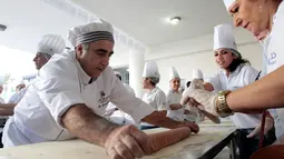 Peserta mempersiapkan adonan untuk roti manousheh raksasa di Choueifat, Beirut, Lebanon (22/11). Roti sepanjang 32 meter ini disiapkan untuk memperingati Hari Kemerdekaan Lebanon dengan tujuan memecahkan rekor dunia. (AFP PHOTO/STR)