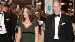 Kate Middleton didampingi Pangeran William berjalan di karpet merah acara penghargaan film British Academy Film Awards (BAFTA) 2018 di London, Minggu (18/2). Kate mengenakan dress panjang berwarna hijau lumut karangan Jenny Packham. (AP/Antonio Calanni)