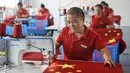Pekerja membuat bendera nasional di sebuah pabrik menjelang Hari Nasional di Wuyi, Provinsi Zhejiang, China, 28 September 2021. Hari Nasional adalah sebuah hari libur nasional di China untuk merayakan hari kebangsaan mereka dan diperingati pada tanggal 1 Oktober setiap tahun. (STR/AFP)