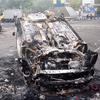 Sejumlah kendaraan dibakar di luar Stadion Kanjuruhan, Malang, Jawa Timur, Minggu (2/10/2022). Sebanyak 127 orang tewas ketika para penggemar yang marah menyerbu lapangan sepak bola setelah pertandingan antara Arema FC dan Persebaya Surabaya pada 1 Oktober 2022. (PUTRI/AFP)