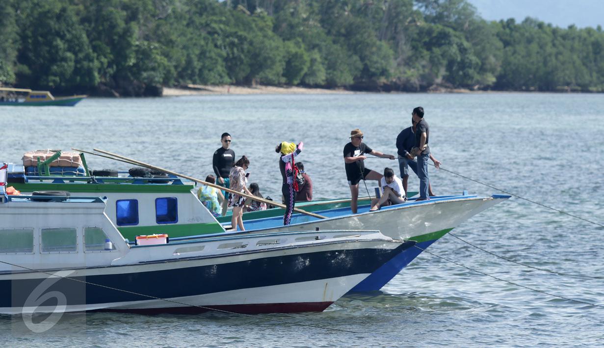 Wisatawan mancanegara menikmati keindahan taman laut Pulau Bunaken di Manado dari atas kapal, Sabtu (17/12). Taman Nasional Bunaken pernah bersaing dengan Pulau Dewata, Bali sebagai tempat wisata laut paling indah di Tanah Air. (Liputan6.com/Fery Pradolo)