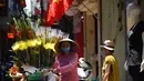 Seorang pedagang kaki lima melewati gang yang didekorasi dengan bendera nasional Vietnam menjelang perayaan Hari Nasional Vietnam di Hanoi (1/9/2020). Peringatan 75 tahun Hari Nasional Vietnam jatuh pada tanggal 2 September 2020. (AFP Photo/Nhac Nguyen)