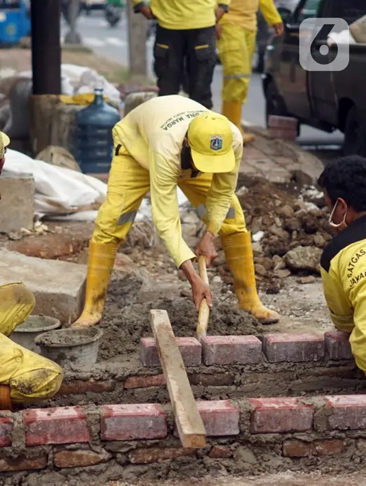 Petugas Sudin Bina Marga memerbaiki trotoar di Jalan Dr. Saharjo, Menteng Atas, Jakarta Selatan, Selasa (17/11/2020). Perbaikan trotoar dilakukan para personel satgas yang tersebar di 10 wilayah kecamatan di Jakarta Selatan. (Liputan6.com/Immanuel Antonius)