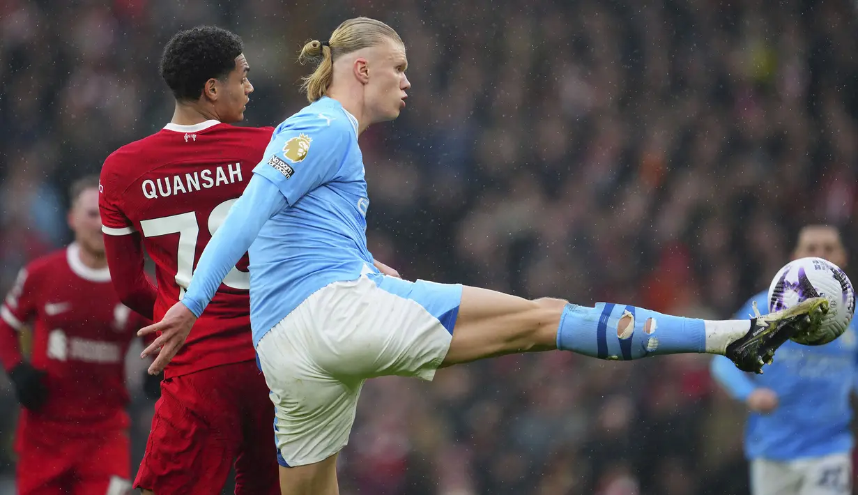 Striker Manchester City, Erling Haaland (kanan) berebut bola dengan bek Liverpool, Jarell Quansah pada laga pekan ke-28 Premier League 2023/2024 di Anfield Stadium, Liverpool, Minggu (10/3/2024). (AP Photo/Jon Super)