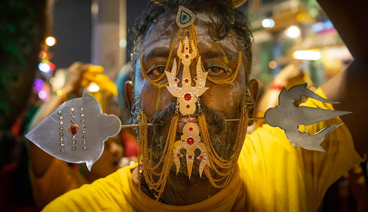 Umat Hindu menusuk pipinya dengan batang logam saat Festival Thaipusam di Batu Caves, Kuala Lumpur, Malaysia, Sabtu (8/2/2020). Acara tahunan ini digelar untuk menghormati Dewa Murugan, mencari berkah, memenuhi sumpah, dan mengucapkan terima kasih. (AP Photo/Vincent Thian)