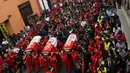 Ribuan warga, beserta petugas dan kerabat mengiringi upacara pemakaman tiga petugas pemadam kebakaran yang tewas di sebuah pabrik sepatu di kota Lima, Peru (21/10). (Reuters/Guadalupe Pardo)