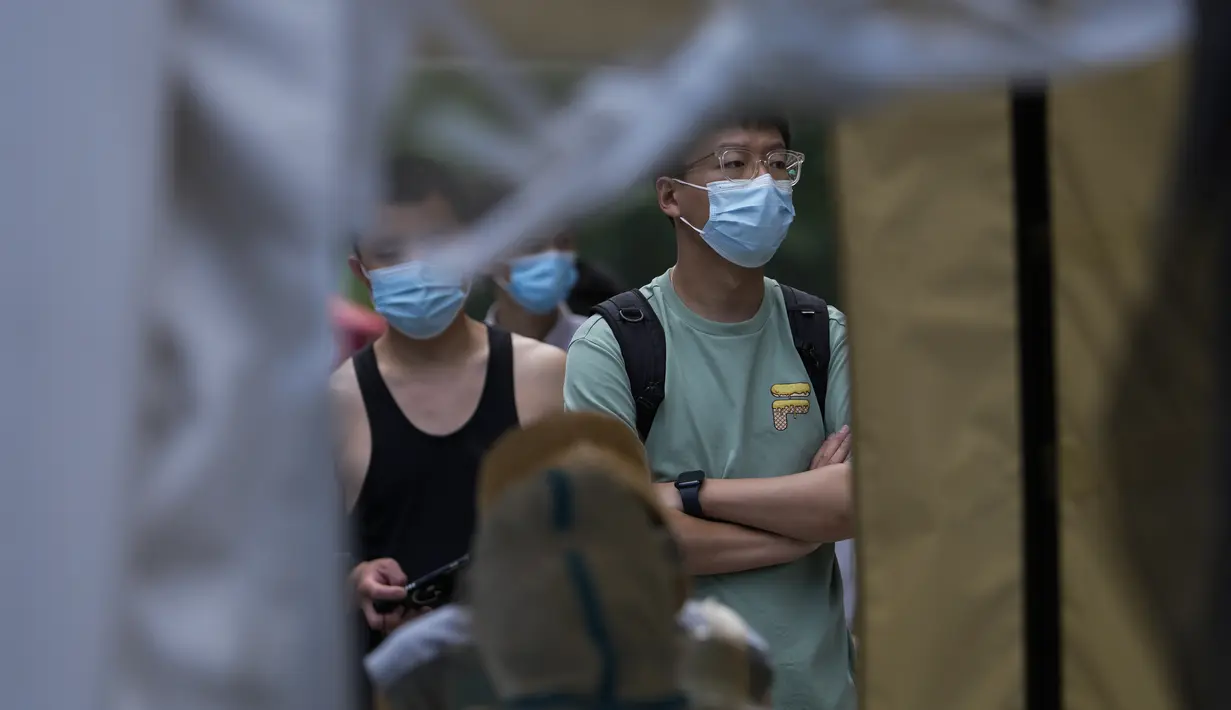 Petugas bersiap mengambil sampel tenggorokan warga di tempat pengujian COVID-19 di distrik Chaoyang di Beijing, Selasa (14/6/2022). Pihak berwenang memerintahkan pengujian massal tiga hari di antara sekitar 3,5 juta penduduknya menyusul terdeteksinya ratusan kasus virus corona COVID-19 terkait dengan klaster bar 24 jam. (AP Photo/Andy Wong)