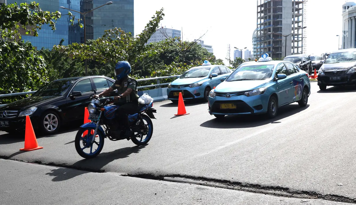 Pengendara mengurangi kecepatan saat melintasi salah satu ruas jalan layang yang retak di kawasan Kemayoran, Jakarta, Kamis (3/1). Akibat retakan ini, para pengendara harus lebih berhati-hati saat melintas. (Liputan6.com/Helmi Fithriansyah)