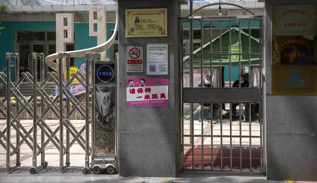 <p>Penjaga keamanan duduk di dalam gerbang sekolah dasar yang ditutup di distrik Chaoyang, Beijing, Kamis (28/4/2022). Beijing mengalihkan lebih banyak kelas secara online pada hari Kamis dalam pengetatan pembatasan COVID-19 lebih lanjut, karena ibu kota China berupaya mencegah penyebaran yang lebih luas. (AP Photo/Mark Schiefelbein)</p>