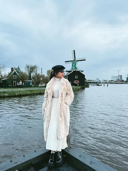 Fuji dibalut turtleneck putih, yang serasi dengan pleated skirtnya, ditumpuknya lagi mengenakan jaket bulu kecokelatan, topi dan sepatu hitam. [Foto: Instagram/fuji_an]