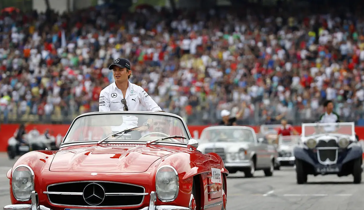 Jelang berlaga di GP Jerman, beberapa pembalap Formula Satu berparade mengelilingi Sirkuit Hockenheim menggunakan mobil antik, (20/7/2014). (REUTERS/Kai Pfaffenbach)