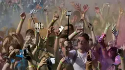 Sejumlah peserta berselfie saat mengikuti festival Holi di Riga, Latvia, (9/7). Orang merayakan Holi dengan saling melemparkan bubuk berwarna-warni atau saling menyiramkan air berwarna-warni. (REUTERS/Ints Kalnins)