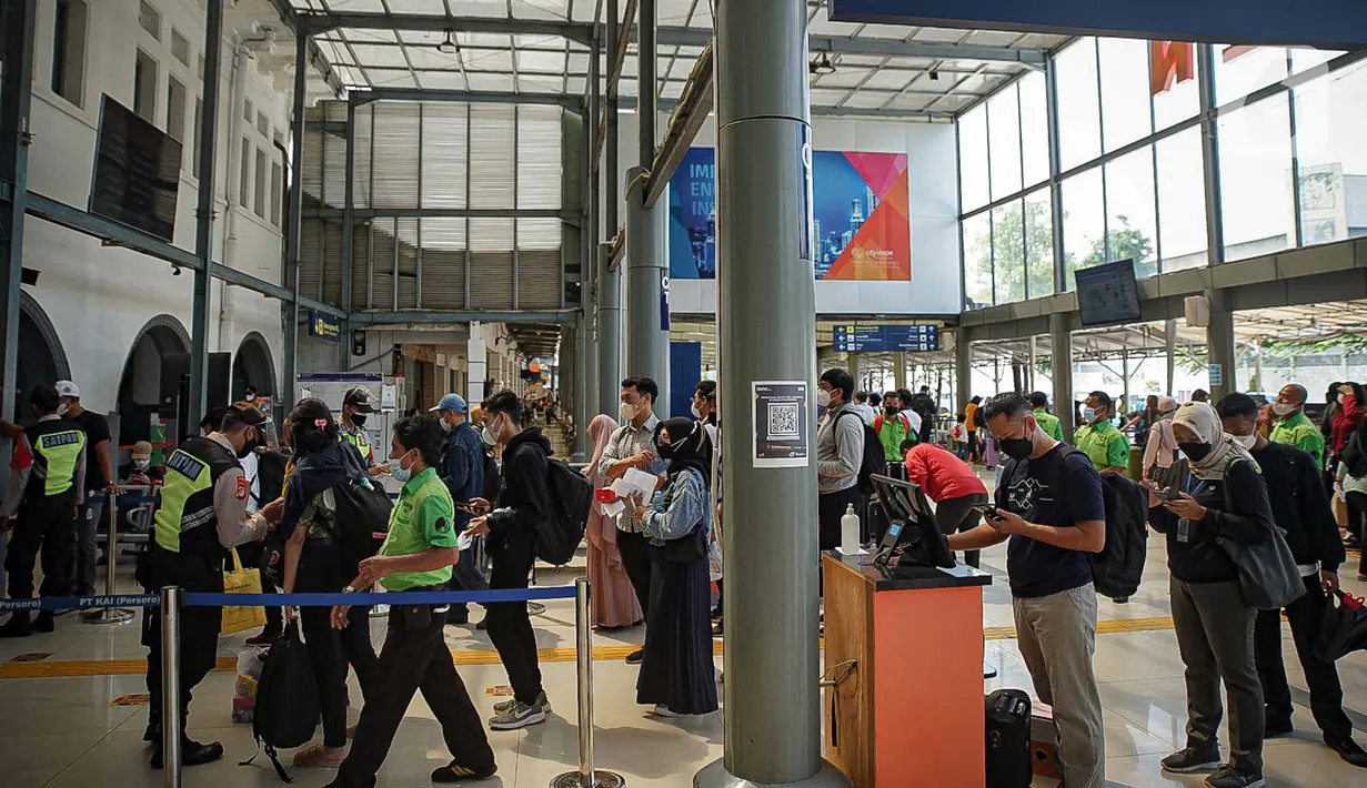 Sejumlah calon penumpang kereta antre memasuki Stasiun Pasar Senen, Jakarta, Jumat (24/12/2021). Penambahan jumlah kereta jarak jauh diharapkan mampu mengakomodir penumpang yang melakukan perjalanan selama libur Natal dan Tahun Baru. (Liputan6.com/Faizal Fanani)