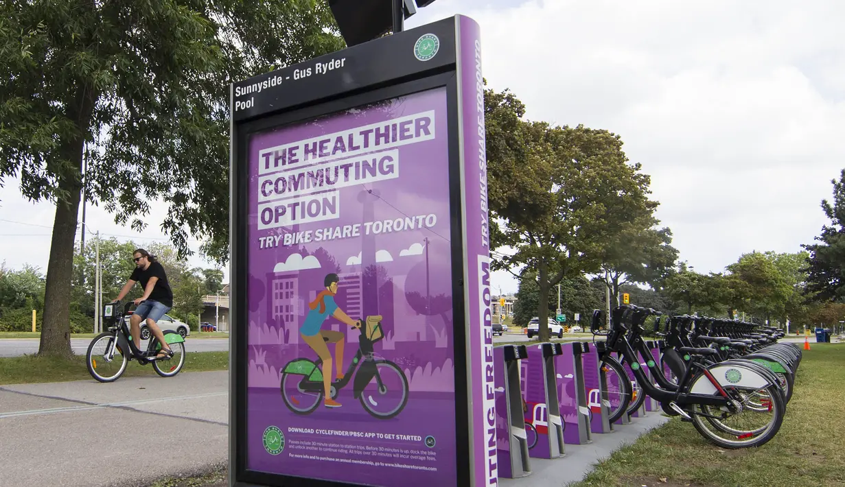 Seorang pria mengendarai sepeda sewaan melewati pos parkir sepeda di Toronto, Kanada, Rabu (2/9/2020). Mulai 2 September, pelanggan layanan penyewaan sepeda Bike Share Toronto dapat menikmati perjalanan gratis di kota tersebut setiap Rabu selama September. (Xinhua/Zou Zheng)