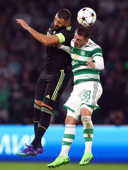 Pemain Real Madrid Karim Benzema (kiri) berebut bola dengan pemain Celtic Josip Juranovic pada pertandingan sepak bola Grup F Liga Champions di Celtic Park, Glasgow, Skotlandia, 6 September 2022. Real Madrid mengalahkan Celtic dengan skor 3-0. (AP Photo/Scott Heppell)