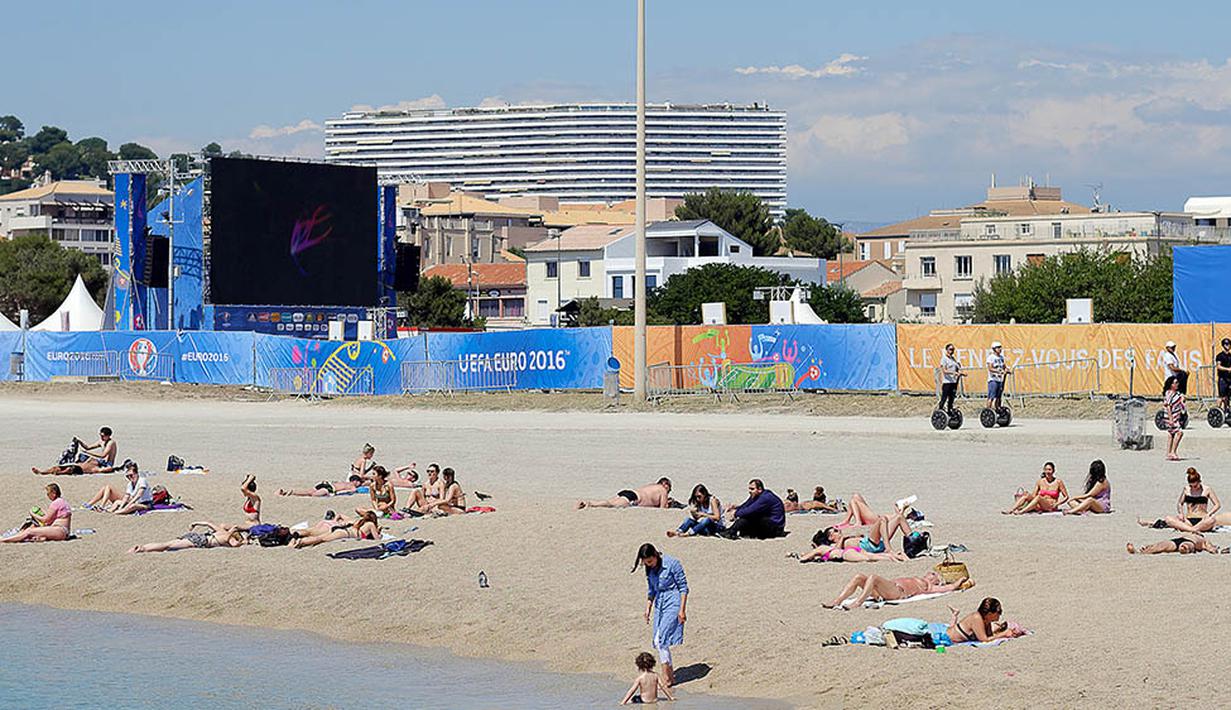 Kondisi fan zone yang berada di tepi pantai tentu menjadi keindahan tersendiri bagi para penggemar sepak bola yang tidak bisa menyaksikan laga langsung di stadion. (AFP/Boris Horvat) 