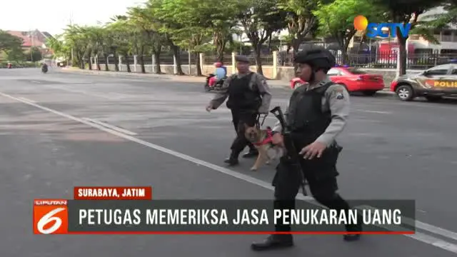 Dengan membawa senjata laras panjang dan satu ekor K-9, aparat kepolisian Polrestabes Surabaya melakukan  pemeriksaan uang rupiah baru.