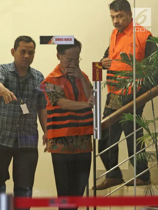 Tersangka anggota DPRD Malang Mohan Katelu dan Salamet mengenakan rompi tahanan seusai menjalani pemeriksaan di Gedung KPK, Jakarta, Rabu (28/3). 5 anggota DPRD Malang resmi ditahan atas dugaan suap APBD-P. (Liputan6.com/Herman Zakharia)