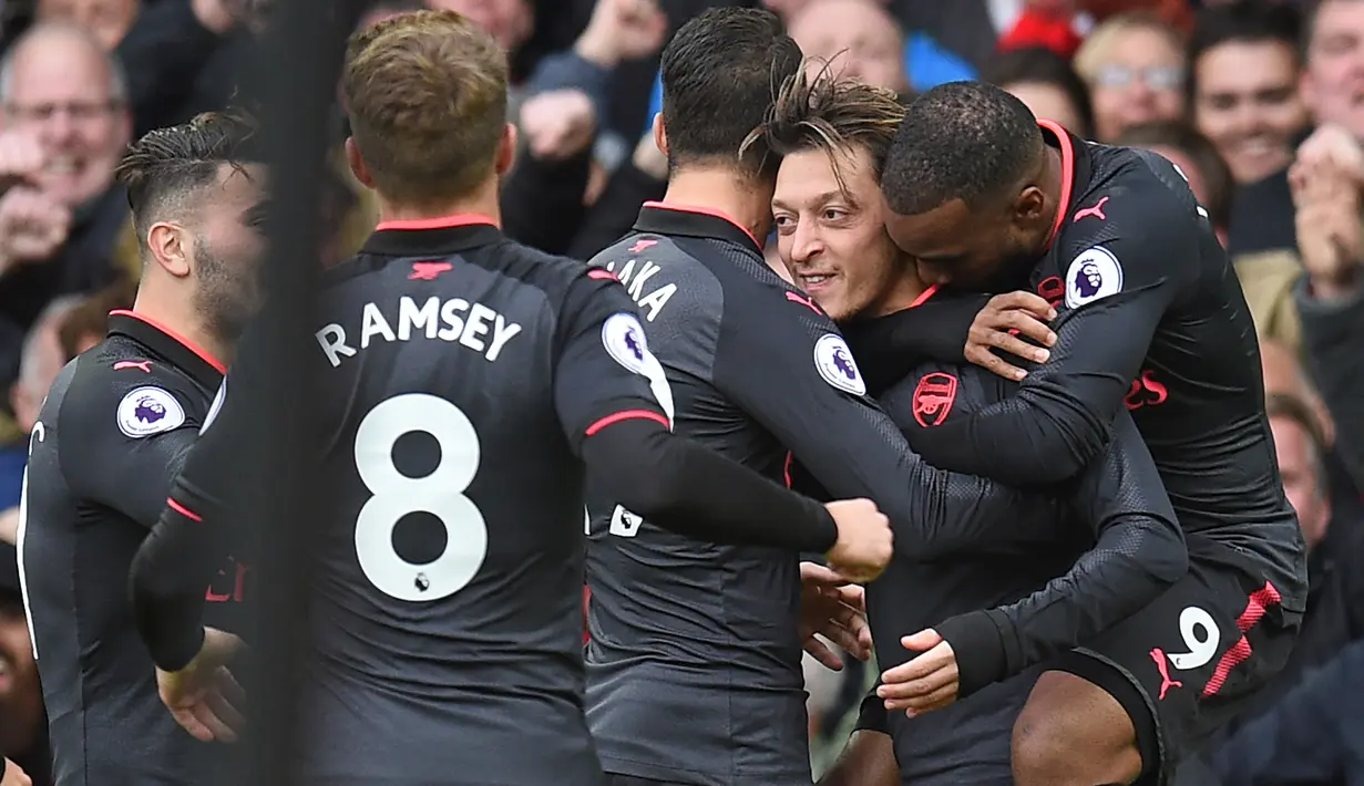 Gelandang Arsenal Mesut Ozil (kedua kanan) bersama rekan setimnya merayakan gol ke gawang Everton pada matchday kesembilan Liga Primer Inggris di Goodison Park, Minggu (22/10). The Gunners menang dengan skor akhir 5-2. (Oli SCARFF / AFP)