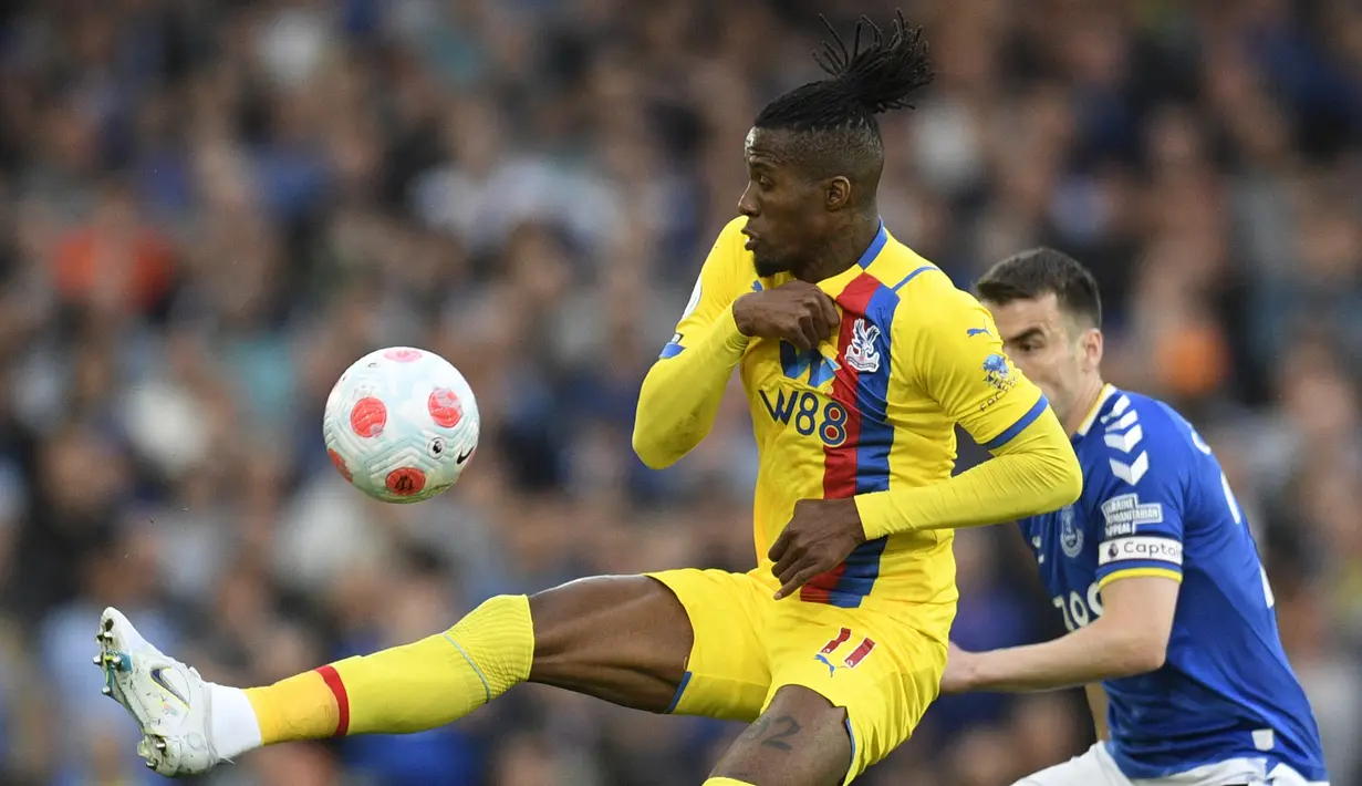 <p>Striker Crystal Palace Wilfried Zaha (kiri) mengontrol bola melewati bek Everton Seamus Coleman pada laga tunda pekan ke-33 Liga Inggris di Goodison Park, Jumat (20/5/2022) dini hari WIB. Everton dipastikan selamat dari zona degradasi usai menang dramatis 3-2 atas Crystal Palace. (Oli SCARFF / AFP)</p>