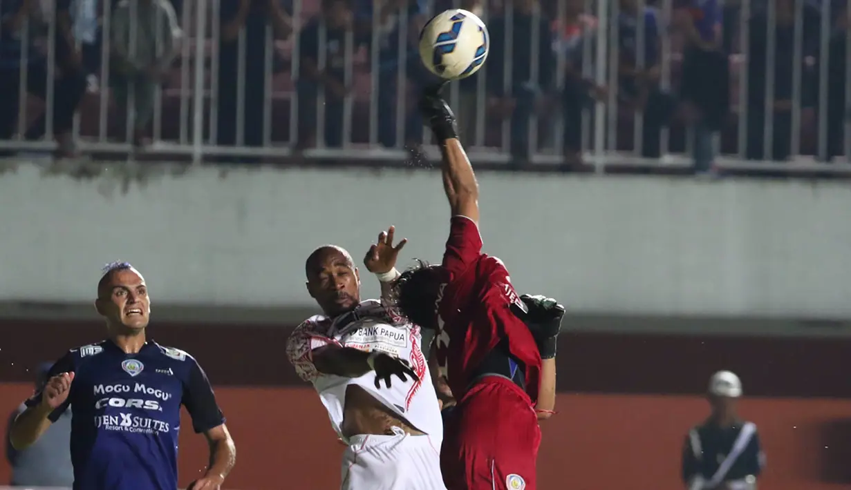 Penjaga gawang Arema Cronus, Made Wardana, mengamankan gawangnya dari gempuran pemain Persipura pada babak 8 besar Piala Jenderal Sudirman di Stadion Maguwoharjo, Sleman, Minggu (13/12/2015). (Bola.com/Nick Hanoatubun)