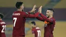 Gelandang AS Roma, Carles Perez (kanan) melakukan selebrasi usai mencetak gol kedua timnya ke gawang SC Braga dalam laga leg kedua babak 32 Besar Liga Europa 2020/21 di Olimpico Stadium, Kamis (25/2/2021). AS Roma menang 3-1 atas SC Braga dan lolos ke babak 16 Besar. (AP/Andrew Medichini)