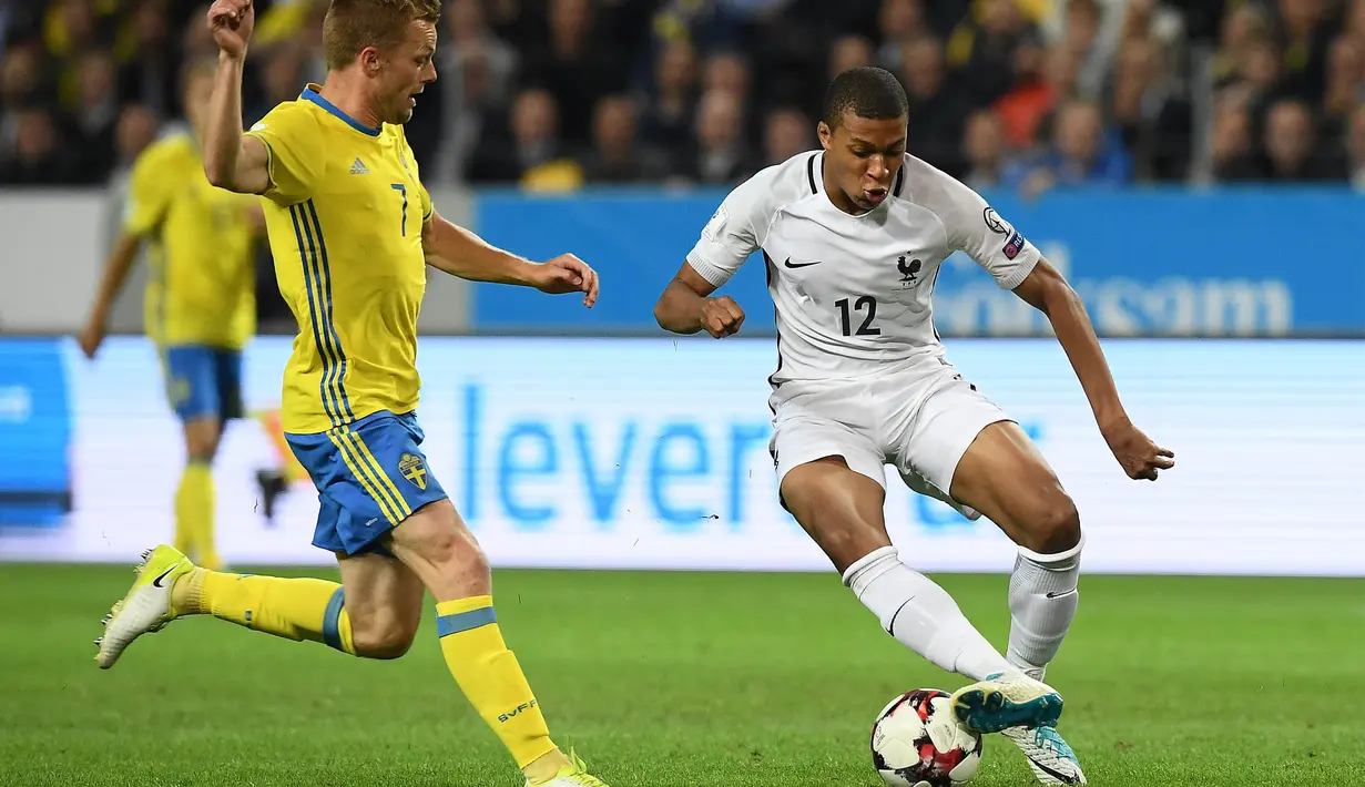 Striker Prancis, Kylian Mbappe, berusaha melewati gelandang Swedia, Sebastian Larsson, pada laga kualifikasi Piala Dunia 2018 di Stadion Friends Arena, Solna, Jumat (9/6/2017). Swedia menang 2-1 atas Prancis. (AFP/Franck Fife)