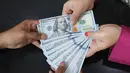 Karyawan menunjukkan lembaran uang Dolar AS di VIP Money Changer, Jakarta, Jumat (5/6/2026). (merdeka.com/Arie Basuki)