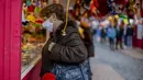 Pengunjung dengan masker mengunjungi pasar Natal di pusat kota Madrid, Spanyol, Rabu (16/12/2020). Penelitian antibodi yang digelar di seluruh Spanyol menunjukkan satu dari 10 penduduk Spanyol telah terinfeksi oleh virus corona COVID-19 pada paruh kedua bulan November lalu. (AP Photo/Manu Fernandez)