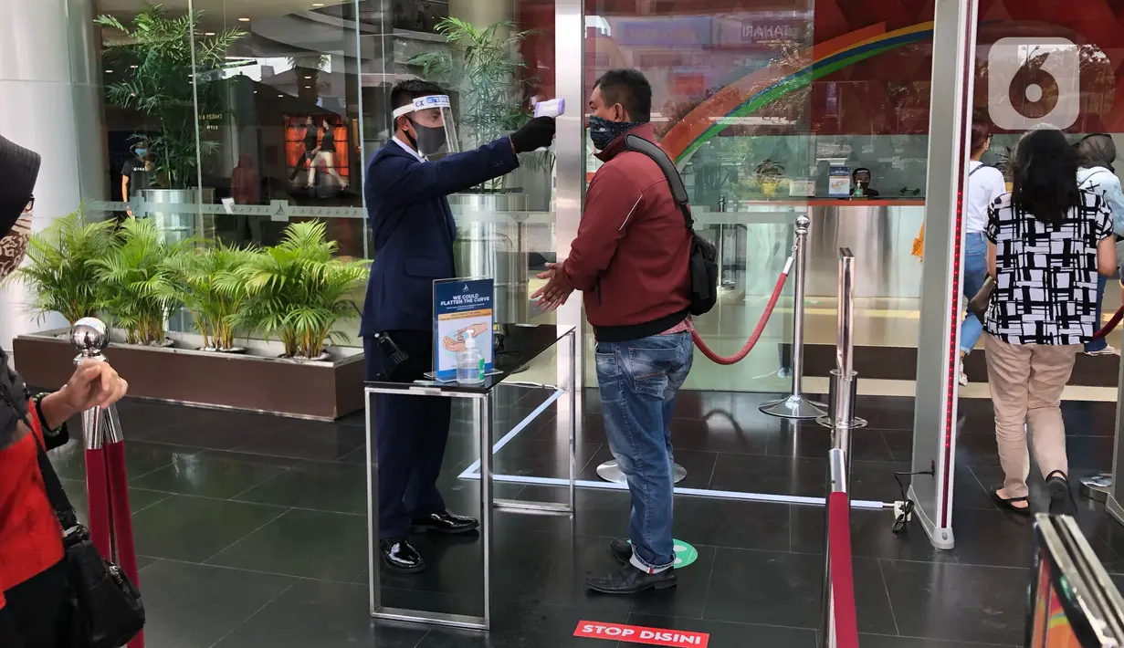 Petugas mengecek suhu tubuh pengunjung di pusat perbelanjaan di Depok, Jawa Barat, Rabu (17/6/2020). Mulai 16 Juni 2020, sejumlah pusat perbelanjaan di Kota Depok kembali beroperasi selama masa PSBB proporsional, namun tetap dengan memerhatikan protokol kesehatan. (Liputan6.com/Immanuel Antonius)