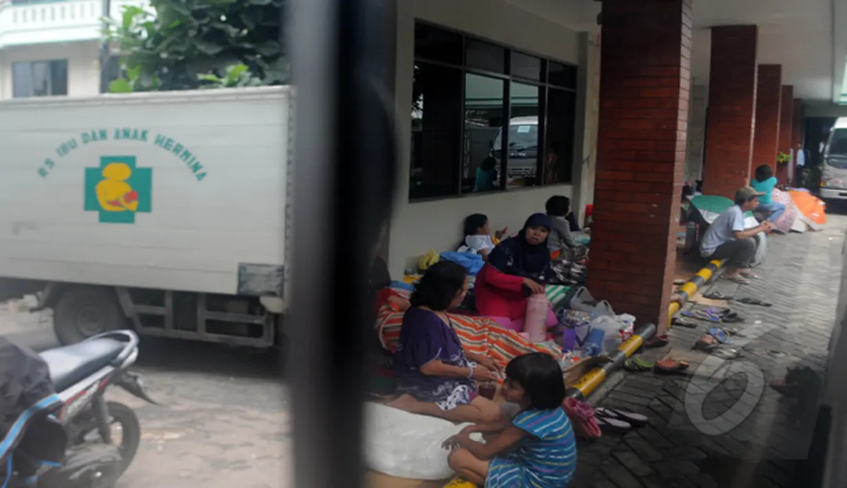Guyuran hujan deras membuat warga Rw 01 Kampung Pulo Jatinegara warga mengungsi di pelataran RS Hermina, Jakarta, Selasa (10/2/2015). (Liputan6.com/Herman Zakharia)