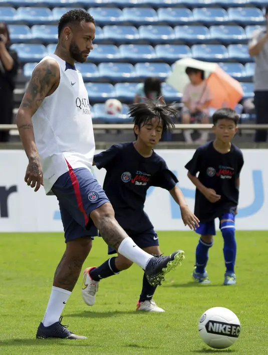 <p>Pemain sepak bola Paris Saint-Germain (PSG) Neymar bermain sepak bola dengan anak-anak saat melakukan pelatihan di Tokyo, Jepang, 18 Juli 2022. PSG berada di Jepang untuk tur pra-musim mereka dan akan memainkan tiga pertandingan persahabatan melawan tim Liga Jepang. (AP Photo/Eugene Hoshiko)</p>